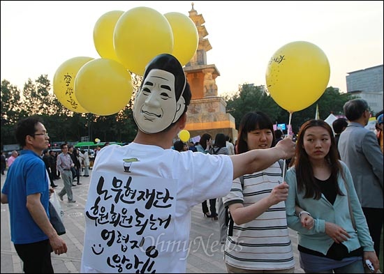  19일 오후 서울 시청광장에서 열린 '노무현 대통령 3주기 추모문화제-노무현이 꿈꾼 나라'에서 노무현재단 자원봉사자가 시민들에게 노란 풍선을 나눠주고 있다.