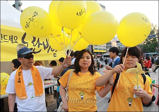  19일 오후 서울 시청광장에서 열린 '노무현 대통령 3주기 추모문화제-노무현이 꿈꾼 나라'에서 노무현재단 자원봉사자가 시민들에게 노란 풍선을 나눠주고 있다.