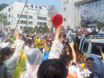 쏟아지는 물줄기 아래 축제에 참석한 시민들이 무더위를 날리고 있다.