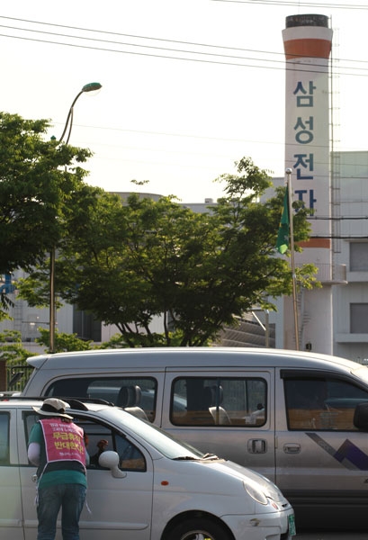  22일 오후 22일 오후 '민주노총 경북지역본부 2012 경북지역 도보순회투쟁'2일차 행진의 마지막 일정으로 선전에 나선 KEC 조합원들이 삼성전자 공장 앞 사거리에서 유인물을 돌리고 있다.