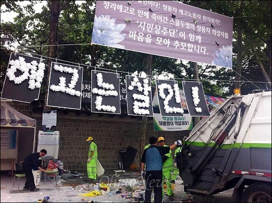 24일 오전 서울 중구 대한문앞에 설치된 쌍용자동차 정리해고 사태 희생자 22명 추모 분향소를 경찰과 용역업체 직원들이 강제철거하고 항의하는 사람들을 강제연행했다. 강제철거된 분향소 시설물들을 청소직원들이 쓰레기차에 싣고 있다.