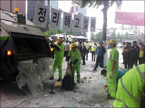 강제집행으로 부서진 분향소 시설물들을 쓰레기차에 싣고 있다.