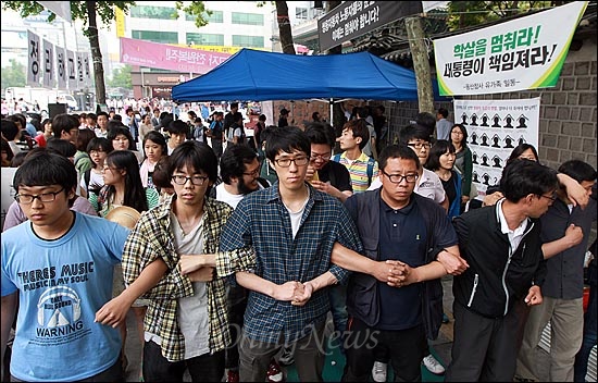 24일 오후 서울 중구 대한문 앞에서 열린 '쌍용자동차 희생자 대한문 분향소 강제 침탈 규탄 기자회견' 도중 쌍용자동차 해고노동자들과 시민들이 분향소를 다시 준비하기 위해 천막을 설치한 뒤 경찰들의 강제 철거를 막기 위해 서로 팔을 끼고 있다.