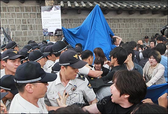 24일 오후 서울 중구 대한문 앞에서 열린 '쌍용자동차 희생자 대한문 분향소 강제 침탈 규탄 기자회견' 도중 쌍용자동차 해고자들이 분향소를 다시 준비하기 위해 천막을 설치하자, 경찰들이 이를 저지하며 천막 철거를 시도하고 있다.