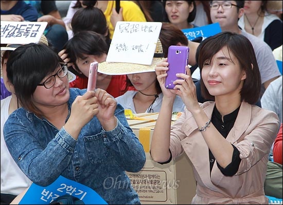 김재연 통합진보당 의원(2011년 한대련 집행위원장)이 집회 장면을 스마트폰으로 촬영하자 옆에 있던 한 대학생이 김 의원의 모습을 촬영하고 있다.