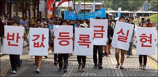"반값등록금 실현"이 적힌 피켓을 한대련 학생들이 청계광장을 출발해 거리행진을 벌이고 있다.