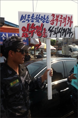 탈북자 단체의 한 회원이 4일 민주통합당 당사 앞에서 임수경 의원의 사퇴를 촉구하는 팻말을 들고 항의하고 있다.