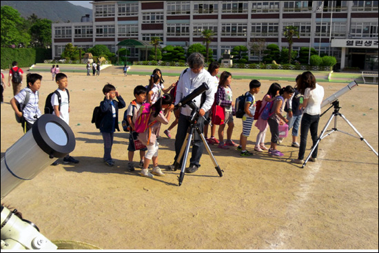 지난 5월 21일, 김해 구봉초등학교 어린이들이 태양필터를 붙인 천체망원경으로 일식 장면을 보고 있다. 태양을 관측할 때는 태양필터가 필수품이다.