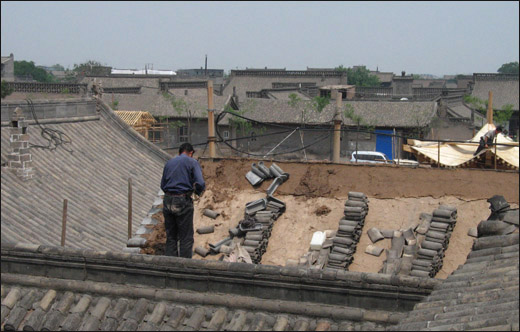 핑야오꾸청에 사는 한 주민이 자신의 집 지붕을 뜯어 고치고 있다. 꾸청의 성벽을 거닐다 만난 모습이다.