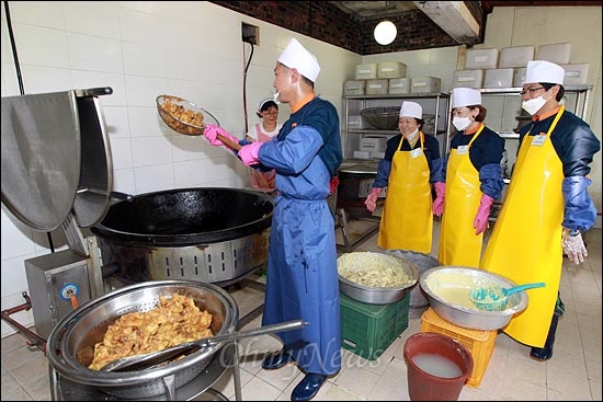 인재근, 진선미, 김광진 의원이 저녁 식사 준비를 돕던 중 한 취사병의 닭튀김 시범을 지켜보고 있다.