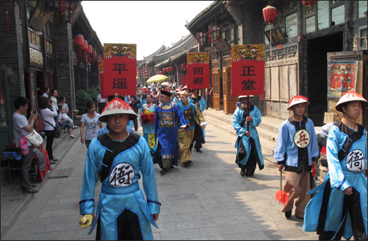 핑야오꾸청의 거리 공연. 전통 복장의 행렬이 거리를 활보하며 여행객들의 눈길을 끌고 있다.
