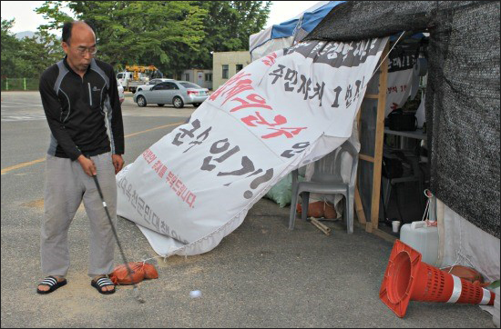 오한흥 운영위원장이 골프장 건설 반대 퍼포먼스를 보여주고 있다.