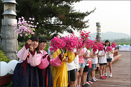  평양에서는 북쪽 주민들이 환영의 꽃을 흔들고 있다.
