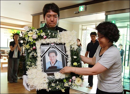 고 김화선 할머니의 영정사진이 나눔의 집으로 들어오자 한 자원봉사자가 영정사진을 붙잡고 오열하고 있다.
