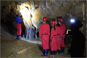 커튼형 종유석 앞에서 동굴 큐레이터의 설명을 듣고 있는 관람객들.