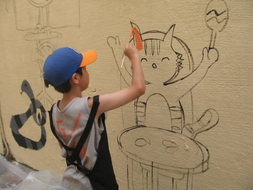 우리와 함께 벽화작업에 참여하여 열심히 그림을 색칠하는 초등학생