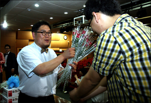 <미권스> 회원이 시사평론가 김용민 교수에게 힘내라는 뜻으로 장미꽃을 전달하고 있다.