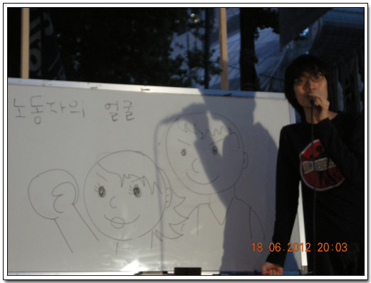 김태권 만화가가 노동자의 얼굴을 그려보이고 있다.