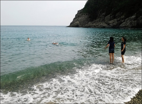 한낮 기온은 땡볕으로 아직까지 바다 물은 차가울 텐데, 여행자는 시원스럽게 수영을 하고 있다.