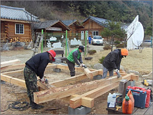 황토구들마을,통나무로 집을 짓는 과정을 배우고 있는 사람들.