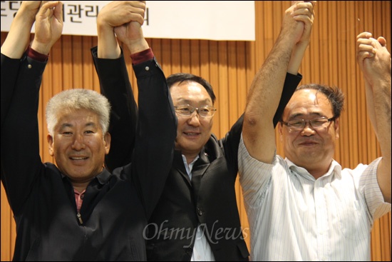  22일 저녁 창원 소재 경남농어업인회관 강당에서 열린 "통합진보당 후보자 합동연설회.토론회"에서 이흥석.강동화.이병하 경남도당 위원장 후보가 손을 들어 인사하고 있다.