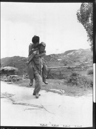 1950. 7. 29. 한 국군이 뙤약볕 속에 부상당한 전우를 업어 후송시키고 있다. 삶과 죽음이 교차하는 전쟁터에서 맺어진 전우애는 눈물겹도록 아름답다. 