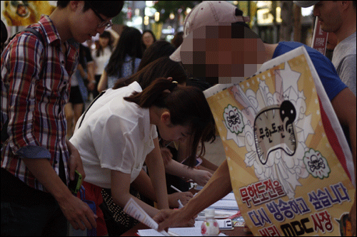 '엠비시를 지켜달라'며 서명활동을 벌이고 있는 노조원과 이에 지지하는 시민들.