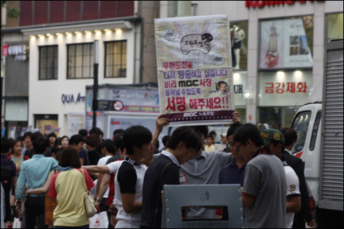 카메라, 아나운서, 엔지니어들이 거리에 나와 방송대신 서명활동을 하고 있다.