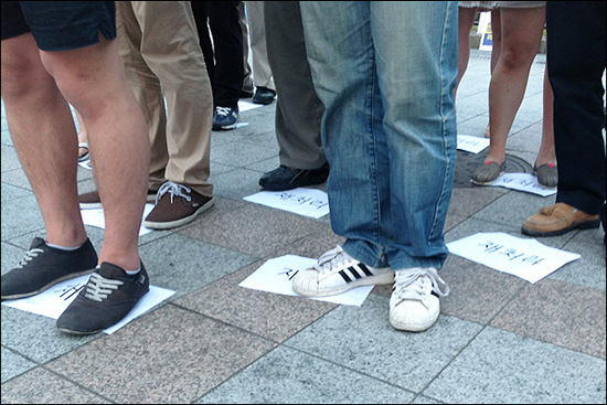 시민들이 바닥에 어지럽게 놓인 '재처리'를 밟고 섰다