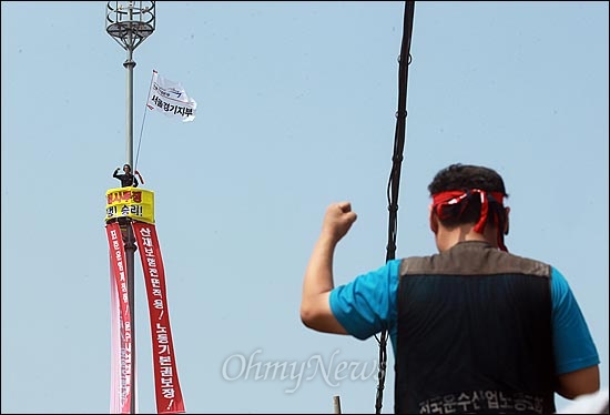 민주노총 공공운수노조 화물연대본부가 운송을 거부하며 총파업에 돌입한 가운데, 25일 오전 경기도 의왕시 의왕내륙물류터미널(ICD) 앞 교통신호 CCTV 관제탑에 이봉주 화물연대 서울경기지부장이 올라 표준운임제 쟁취와 노동기본권 보장 등을 요구하며 고공시위를 벌이고 있다.