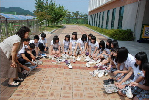 울산 울주군 구영중학교 학생들과 박영희 교무부장이 25일 캄보디아 자매결연 학교에 선물한 신발을 말리며 담소하고 있다