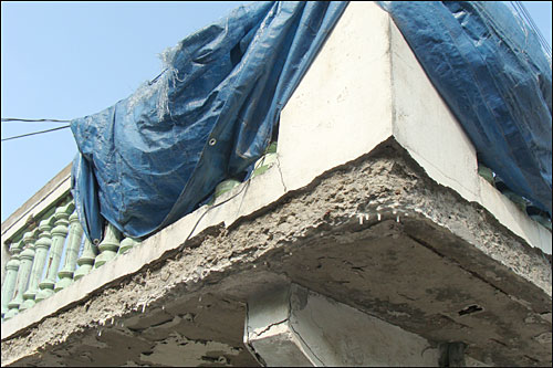 수원시 이목동 김아무개 할머니 집 슬래브 지붕 아래 처마 부분은 시멘트로 미장한 표면이 절반은 떨어져 나가 콘크리트가 드러나 있고, 지붕을 떠받치는 구조물도 균열이 심한 상태였다.