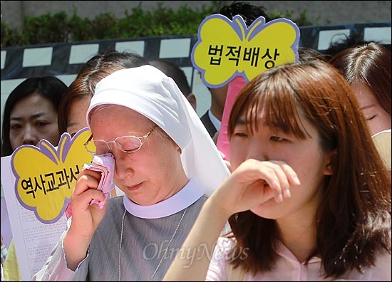  27일 오후 서울 종로구 일본대사관 앞에서 열린 '일본 위안부 문제 해결을 위한 1028차 수요집회'에서 경기자주여성연대 회원들이 할머니들을 생각하며 쓴 편지를 낭독자하, 참석자들이 눈물을 흘리고 있다.