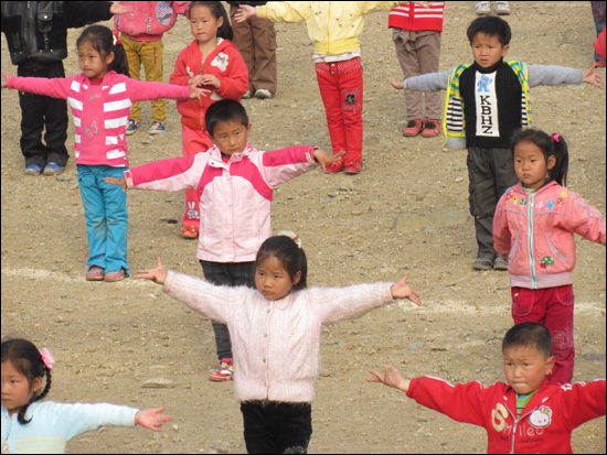 학교 운동장에서 매스게임을 연습하는 초등학생들.