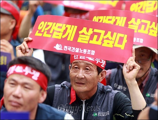 '건설노동자 총파업 투쟁승리 결의대회'가 28일 오후 서울광장에서 1만여명이 참석해 열리는 가운데 한 노동자가 "인간답게 살고싶다"는 손피켓을 들고 있다.