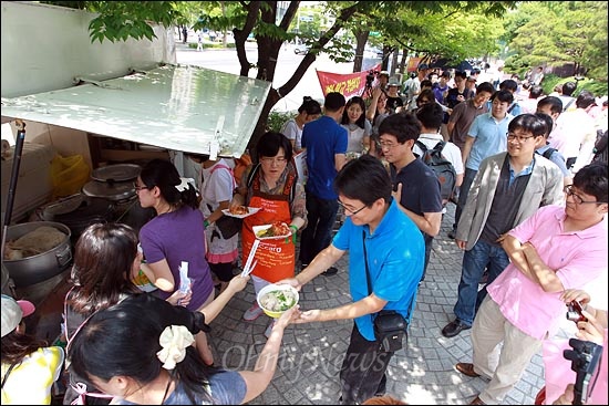 전복과 인삼이 듬뿍 담긴 삼계탕을 받기 위해 MBC노조원들이 밥차 앞에 길게 줄을 서 있다.