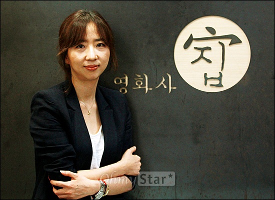  영화<내 아내의 모든 것>을 제작한 영화사 집의 이유진 대표가 5일 오후 서울 논현동에 위치한 자신의 사무실에 있는 CI 앞에서 미소짓고 있다.