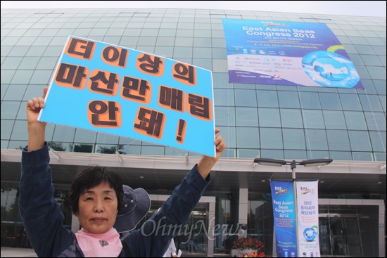  '마산해양신도시건설사업반대시민대책위원회'는 '동아시아 해양회의'가 열리고 있는 9일 오전 창원컨벤션센터 앞에서 기자회견을 열고 "타당성 없는 가포신항을 위해 19만평 마산만 매립을 용납할 수 없다"고 밝혔다. 사진은 이경희 경남진보연합 대표가 피켓을 들고 서있는 모습.