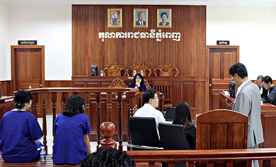 지난 7월 11일 프놈펜 지방법원 101호 법정의 모습. 수감중인 여성들이 재판이 속개되기를 기다리고 있고, 국과수 법의학팀 김형중 박사(가운데)가 재판에 앞서 재판 프리젠테이션 자료를 점검하고 있다.