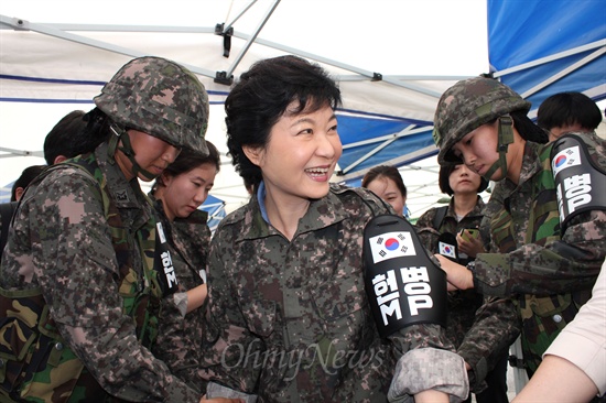 18일 강원도 철원군 김화읍 3사단(백골부대)을 방문한 새누리당 대선주자 박근혜 의원이 여군들의 도움을 받아 야전 상의(전투복)을 입고 있다. 