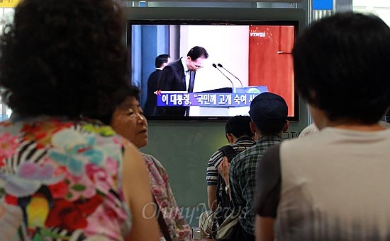 24일 오후 서울역 대합실에서 시민들이 이명박 대통령의 친인척, 측근 비리에 대한 대국민 사과 기자회견을 TV 모니터를 통해 지켜보고 있다.