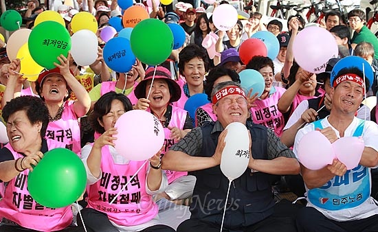  전국민주노동조합총연맹과 한국노동조합총연맹 등 30여개 단체 회원들이 24일 오후 서울 여의도 국회 앞에서 최저임금법 개정 촉구 노동·학생·시민 결의대회를 열고 생계비를 보장하는 최저임금법 개정의 의지를 담아 '최저임금'이라고 적힌 풍선을 터뜨리는 상징의식을 벌이고 있다.