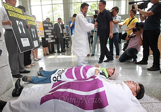  25일 오후 서울 용산구 백범기념관에서 통합진보당 중앙위원회가 열리는 가운데 지난 5.12 중앙위 폭력사태와 관련 제명된 용혜랑 당원의 인천시당부위원장 후보 자격 박탈 무효를 요구하며 용혜랑 남동구의원과 김맹규 당원이 바닥에 드러누워 시위를 벌이며 강기갑 통합진보당 대표의 출입을 막고 있다.