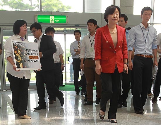 통합진보당이 이석기, 김재연 의원의 제명 처리 문제를 놓고 내홍을 겪고 있는 가운데, 25일 서울 용산구 백범기념관에서 열린 통합진보당 중앙위원회에 심상정 통합진보당 의원이 회의실로 향하자, 박자은 전 한대련 의장이 김재연 의원에 대한 제명 방침을 철회할 것을 요구하며 피켓시위를 벌이고 있다.