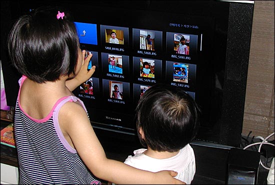 다음TV+와 연결된 TV화면을 통해 사진을 보고 있는 아이들