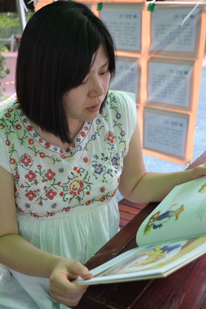 임신 6개월째인 한 주민이 아동성폭력 예방 추천동화 전시 부스에서 동화책을 읽고 있다.