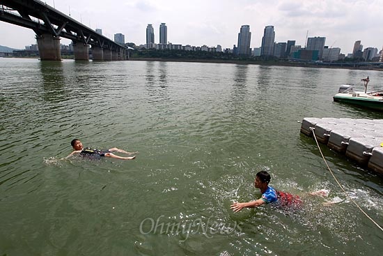 한강에 녹조현상이 발생한 가운데 8일 오후 서울 광진구 자양동 청담대교 아래에서 구명조끼를 착용한 한 어린이가 물놀이를 하고 있다.