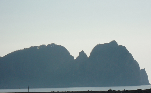 해안에 있는 바위 산이 박쥐가 날개를 펴고 앉아있는 모습이다.