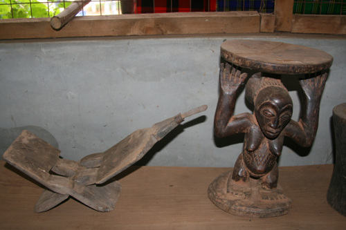 여자들이 앉아서 코코넛을 갈아 음식을 만드는 도구인 움쥐(mbuzi -왼쪽)와 의자   