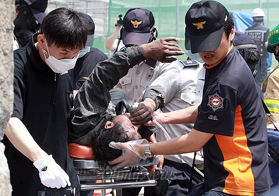  13일 오전 서울 종로구 경복궁 옆 국립현대미술관 신관 신축공사장에서 화재가 발생, 출동한 소방대원과 경찰이 부상자를 구조해 구급차로 이송하고 있다.